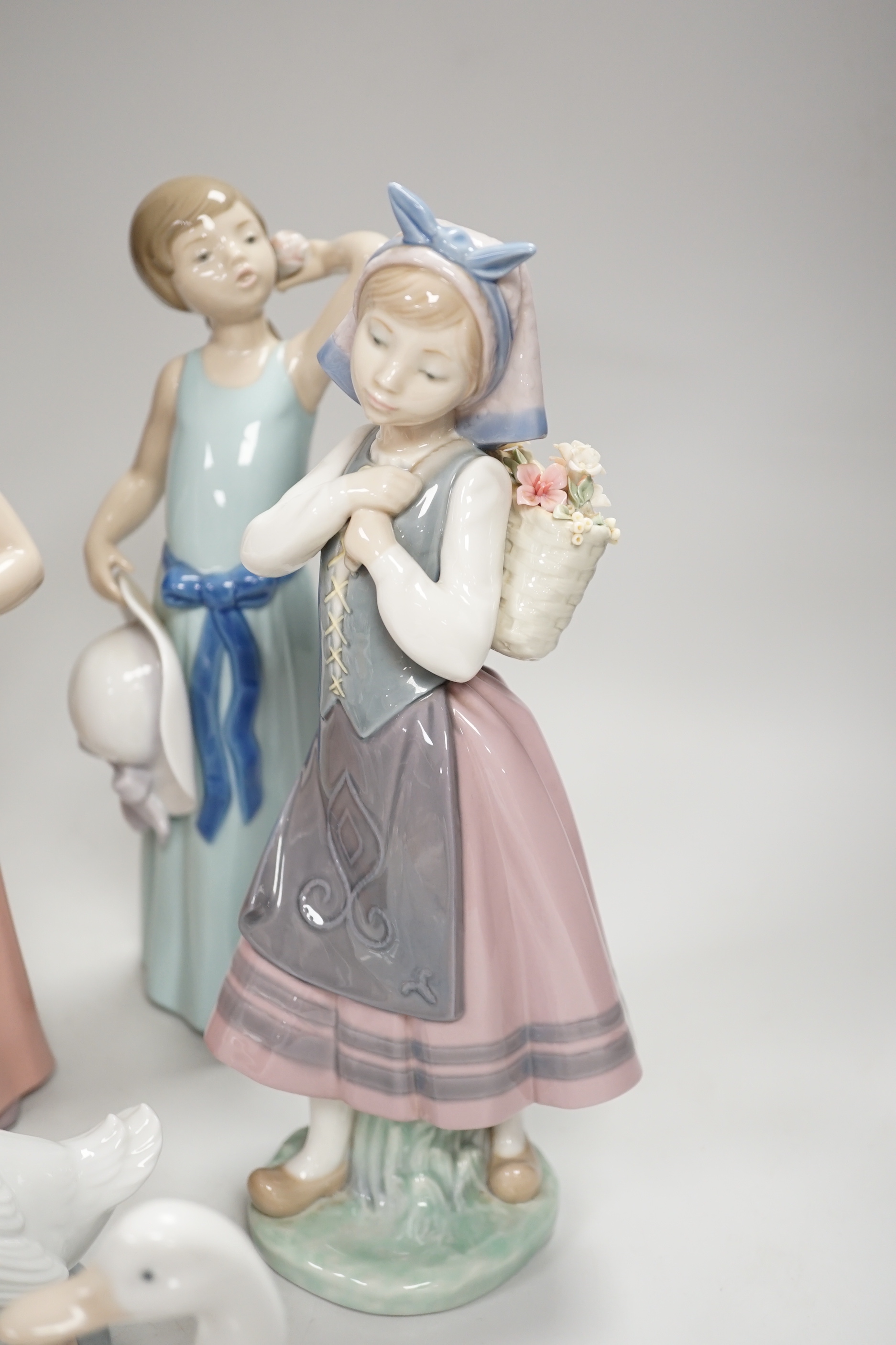 Six Lladro figures of girls, three with hats, one with a Teddy, two peasant girls with flowers and two Nao ducks, the largest 26cm high (8)